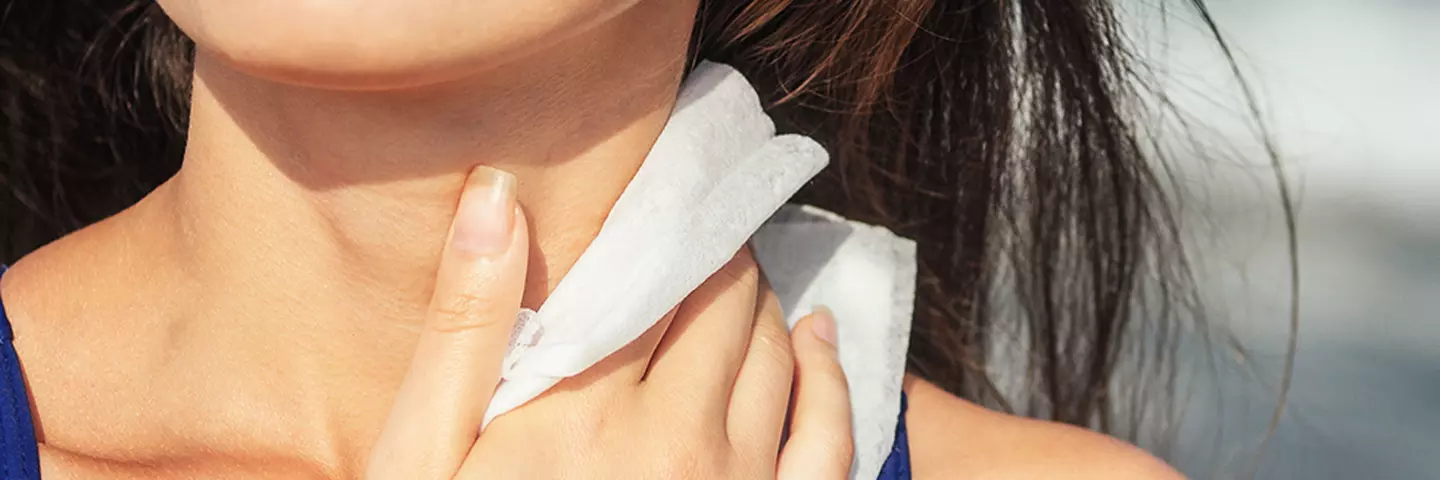 Frau mit Papiertaschentuch am Hals