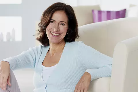 Frau sitzt entspannt auf dem Boden